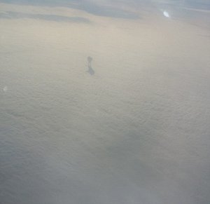 Mysterious shadow figure walking on clouds plane passenger (2)[1].jpg